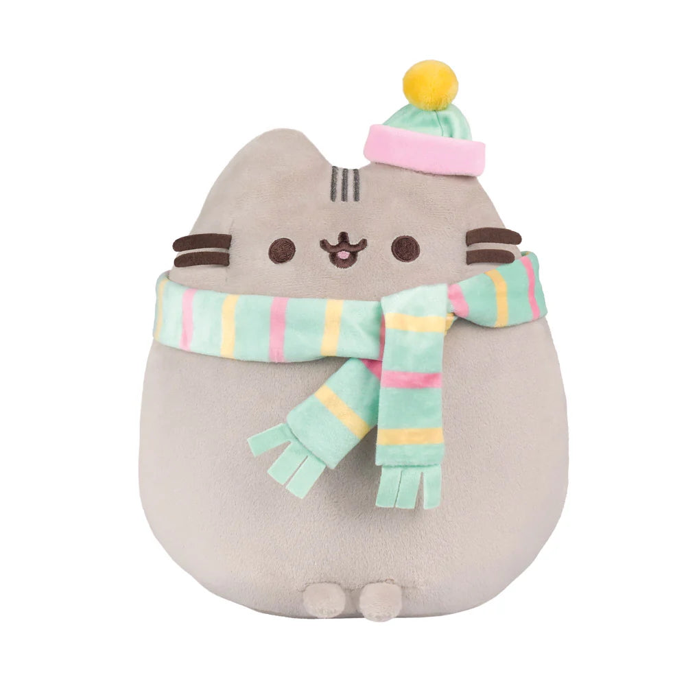 Adorable cuddly Pusheen soft toy with embroidered details and a super cute scarf and hat. Pusheen is a sweet, curious, lazy, & plump tabby cat that loves to have adventures. Her hobbies include blogging