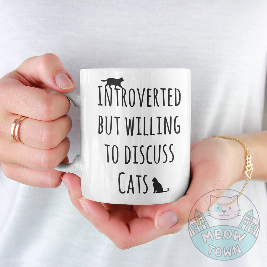 Funny 'Intorverted but willing to discuss cats' slogan ceramic mug, from our Meow Town Special collection. Printed exclusively for You in the UK in-house by us. Funny and unique present for your cat lover friends and family.