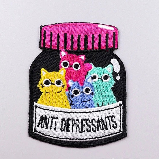 Cute embroidered iron-on patch with multicolour cats and ‘Anti depressants’ slogan. A perfect way to bring new life to your old garments or to cover small holes or marks with these cute kittens!