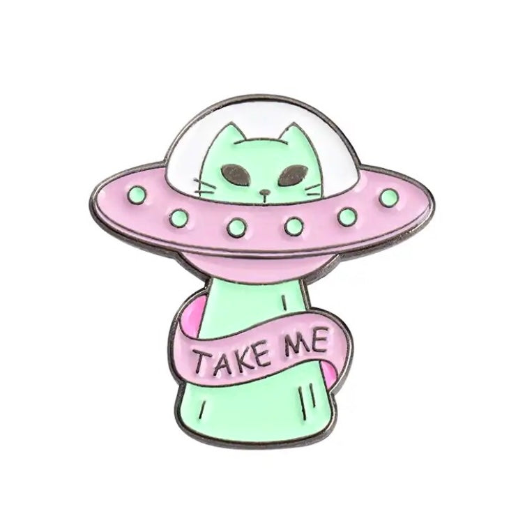 Cute enamel alien kitty pin badge in a UFO with ‘Take Me’ slogan.