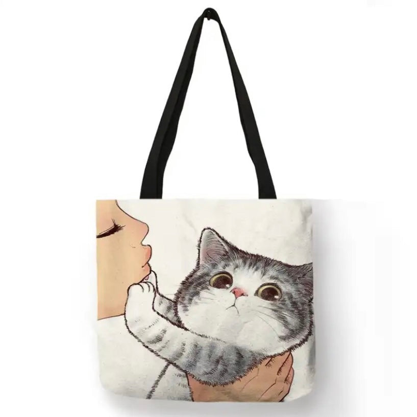 Super cute tote bag with double sided kitty print. With sturdy black handles and a spacious interior, it's perfect for toting your essentials while showcasing your love for cats. 