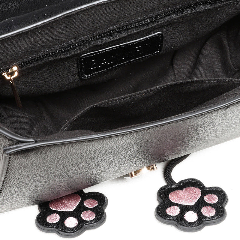 cat bag dangling paw charms and bow closeup