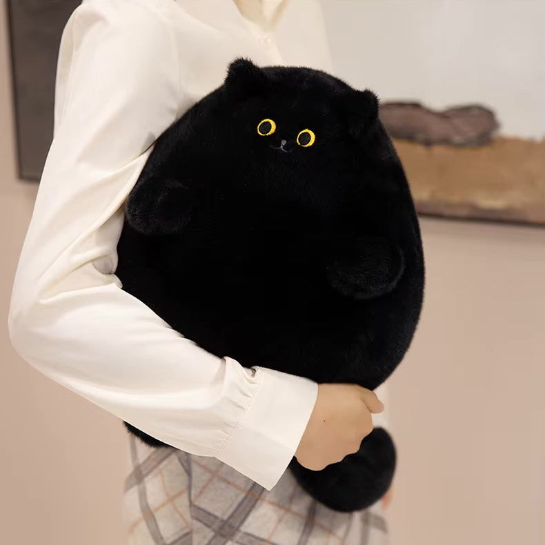 Person holding a black plush cat toy with yellow eyes.