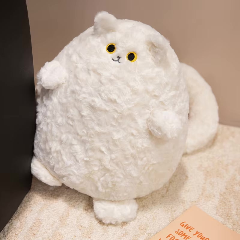 White fluffy cat-shaped plush toy on a beige surface
