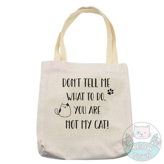 Funny and handy linen touch tote bag printed in the UK by us at Meow Town exclusively for You. 'Don’t tell me what to do, you are not my cat’ slogan with kitty and paw print. Natural beige bag colour. Durable