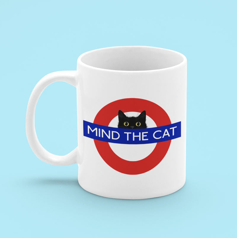 white mug with mind the cat london tube station design with black cat