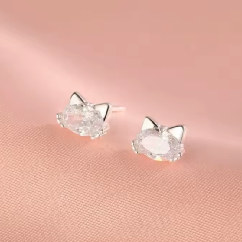 Cat-shaped earrings on a pink background