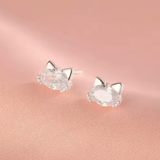 Cat-shaped earrings on a pink background