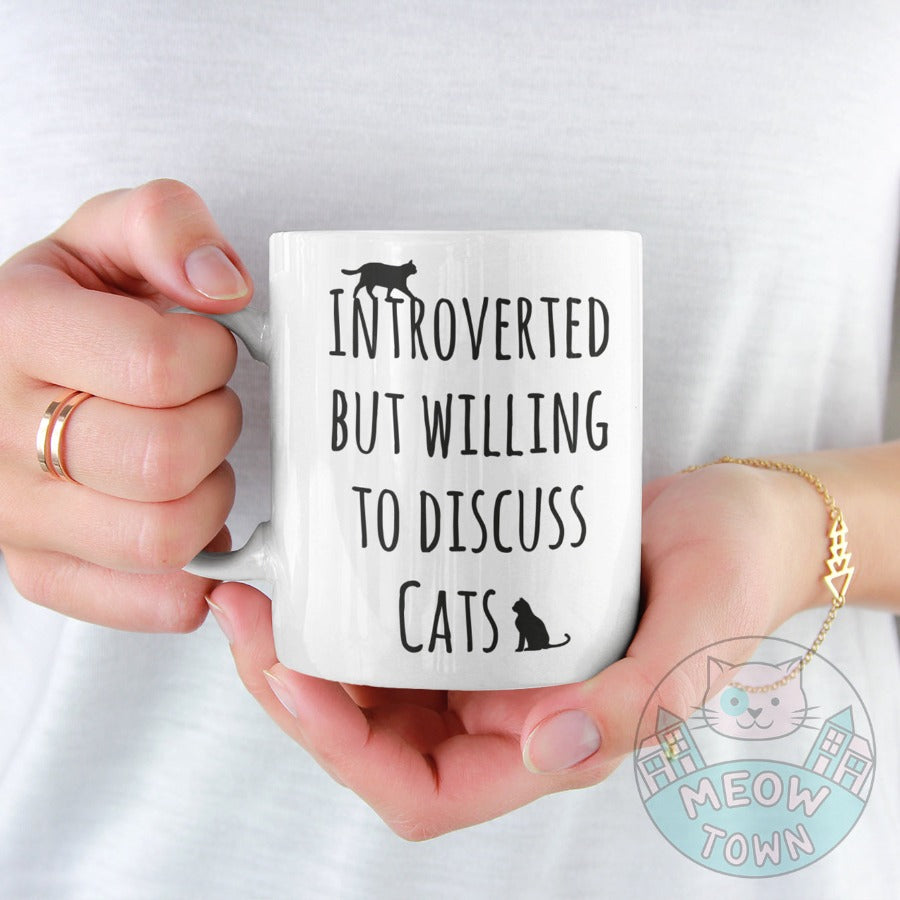 Funny 'Intorverted but willing to discuss cats' slogan ceramic mug, from our Meow Town Special collection. Printed exclusively for You in the UK in-house by us. Funny and unique present for your cat lover friends and family. 