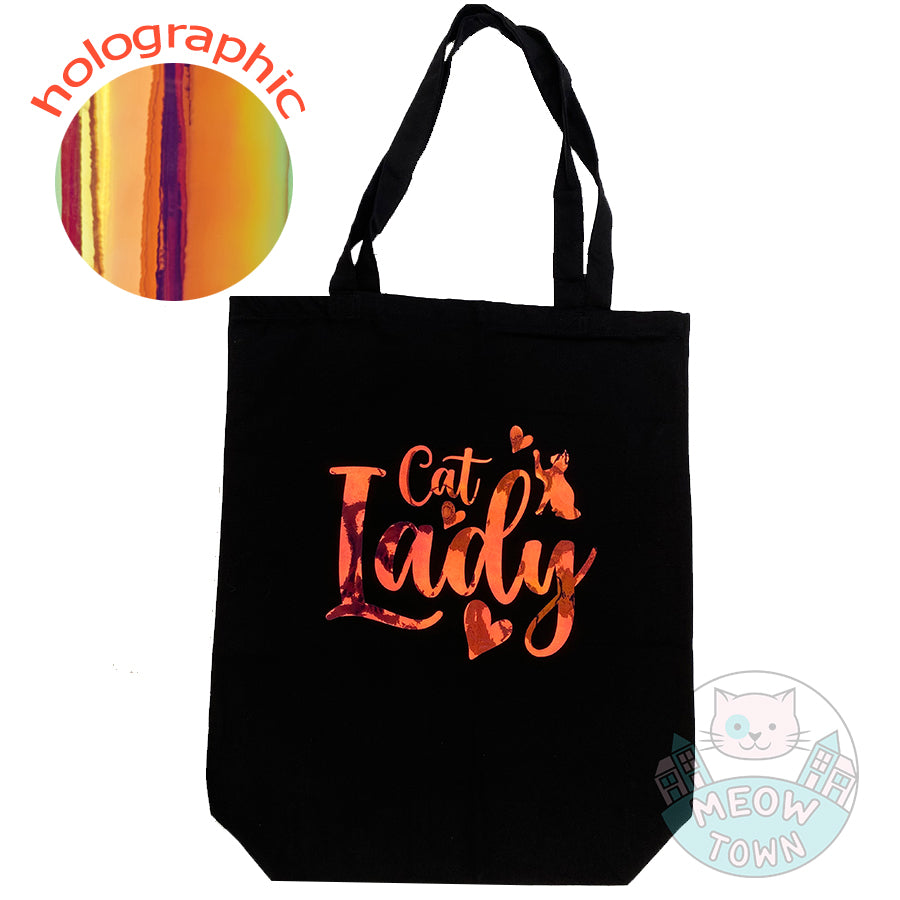 Meow Town Special, designed and printed in the UK by our team exclusively for You. Lovely Cat Lady slogan with kitty and hearts design with holographic vinyl print. Holographic print changes colour when looked from different angle, such as yellow/orange/green,etc. 100% cotton heavy duty black canvas tote bag.