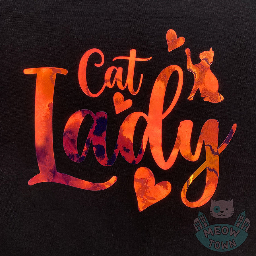 Meow Town Special, designed and printed in the UK by our team exclusively for You. Lovely Cat Lady slogan with kitty and hearts design with holographic vinyl print. Holographic print changes colour when looked from different angle, such as yellow/orange/green,etc. 100% cotton heavy duty black canvas tote bag.
